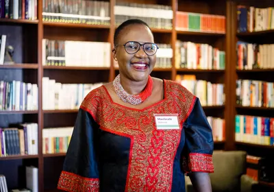 smiling woman against a backdrop of bookshelves